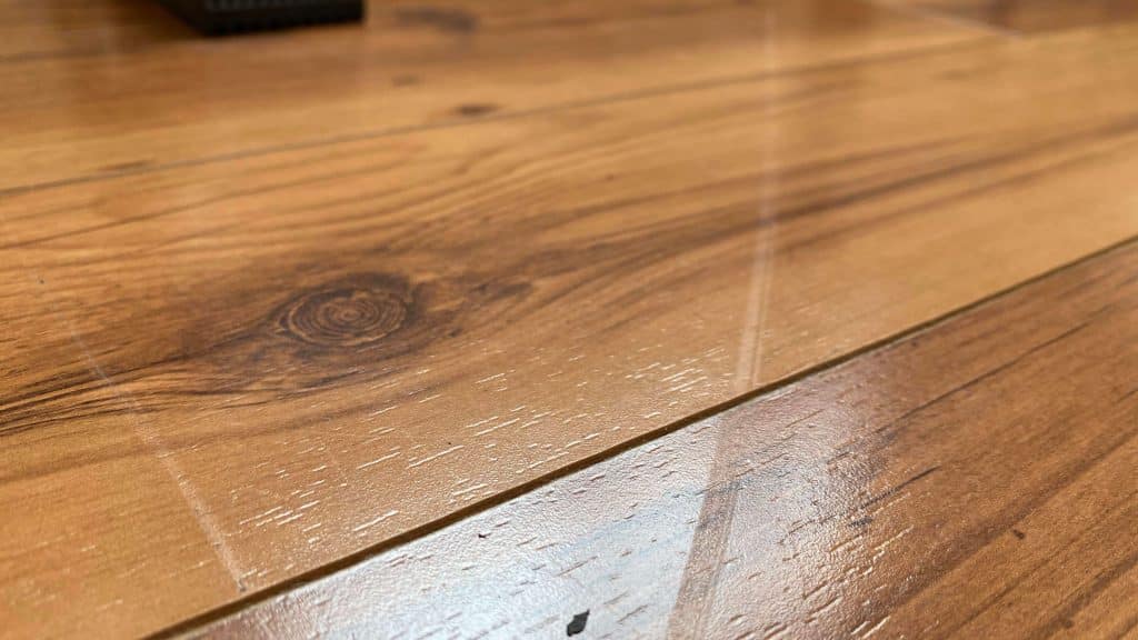A close-up showing a shallow drag mark on a wooden floor, which can be fixed by ReCoat Revolution.