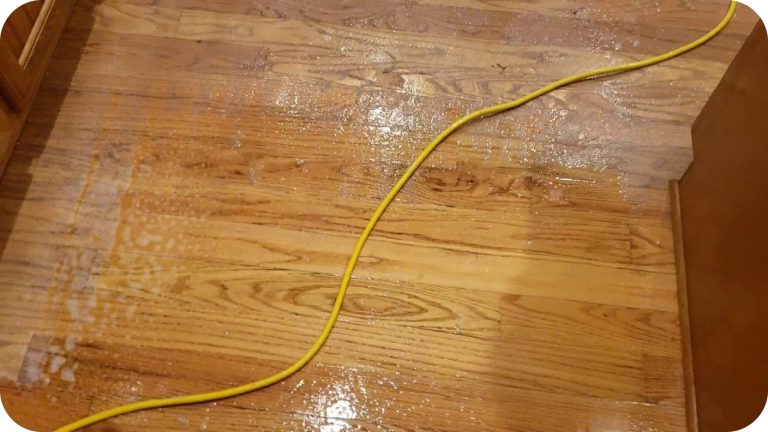 A hardwood floor with only a portion of acrylic wax removed by ReCoat Revolution, showcasing the dull appearance that can be caused by an extreme amount of acrylic wax build-up.