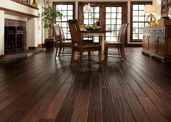 A traditional-style, residential dining space with dark, hand-sawn hardwood flooring that can easily be maintained and refinished when needed by ReCoat Revolution.