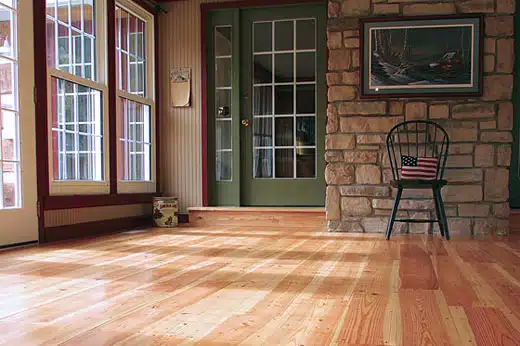 An image showcasing the color variations of rice mill reclaimed heart pine flooring with hand-beveled edges, refinished by ReCoat Revolution to bring out the honey and wheat tones with a matte finish.