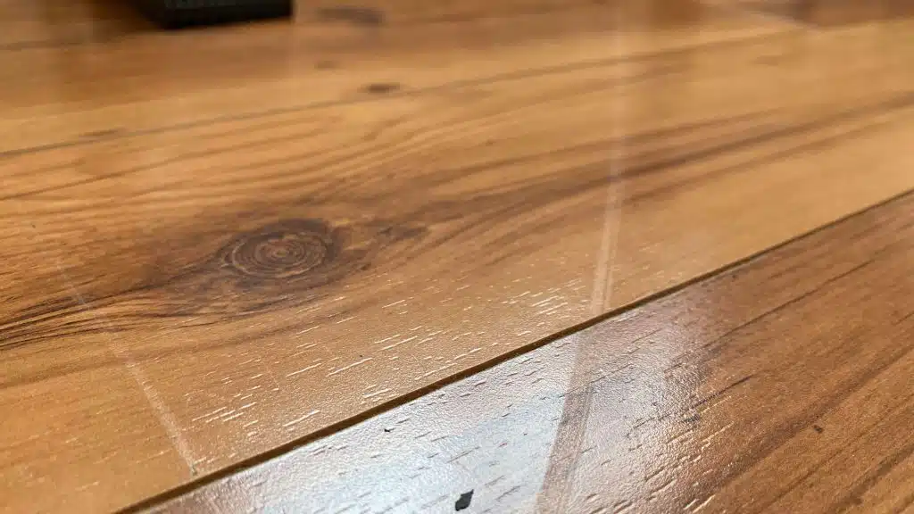 A close-up showing a shallow drag mark on a wooden floor, which can be fixed by ReCoat Revolution.