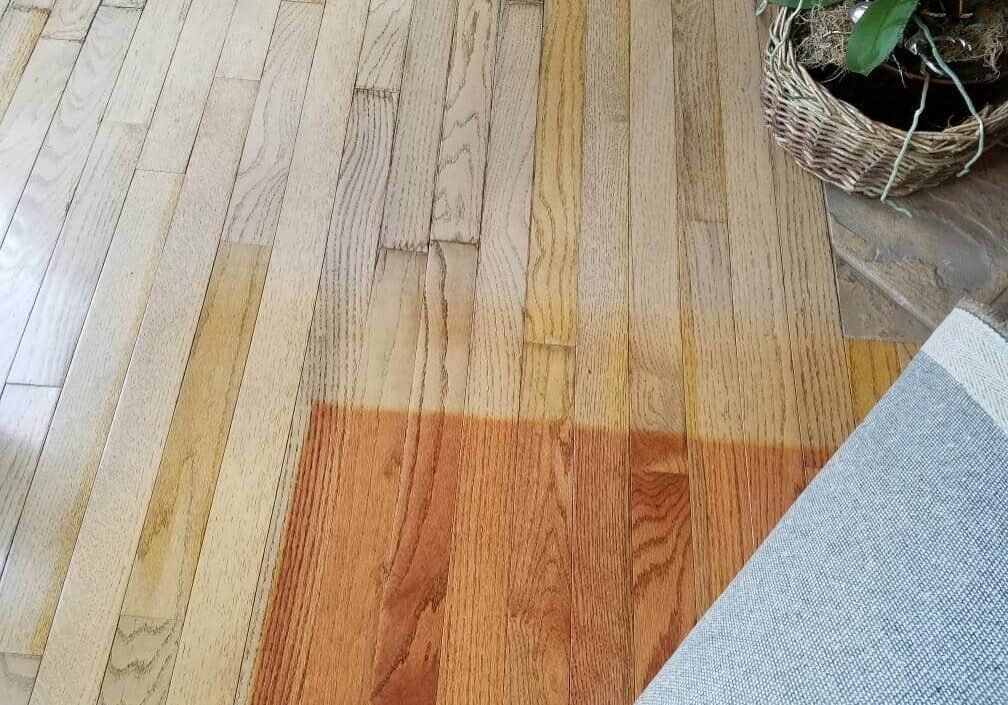An image showing the immense color difference between hardwood flooring exposed to UV and the portion that had been covered by an area rug, which can be refinished and corrected by ReCoat Revolution.