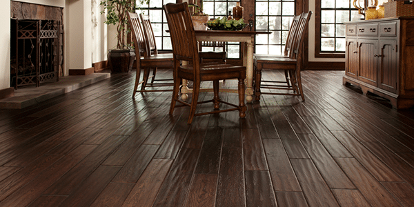 A traditional-style, residential dining space with dark, hand-sawn hardwood flooring that can easily be maintained and refinished when needed by ReCoat Revolution.