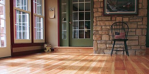 An image showcasing the color variations of rice mill reclaimed heart pine flooring with hand-beveled edges, refinished by ReCoat Revolution to bring out the honey and wheat tones with a matte finish.
