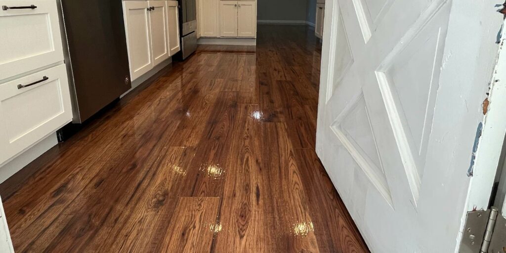Looking in to a home from an external door of a small kitchen with a newly refinished floor completed by ReCoat Revolution.