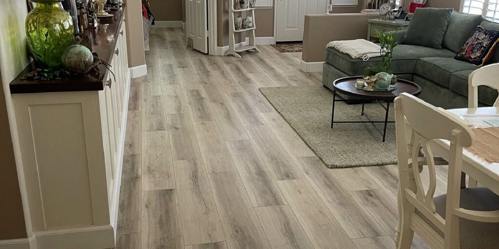 A light-colored hardwood floor in a residential living room restored and refinished by ReCoat Revolution.
